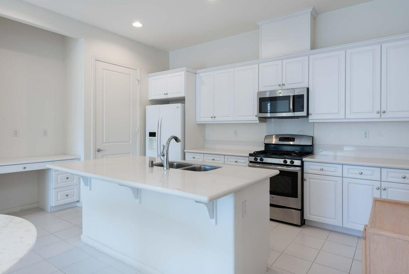2609 Via Calderia Palm Desert, CA 92260 - Photo 6 of 10 a kitchen with stainless steel appliances granite countertop a sink stove top oven and microwave