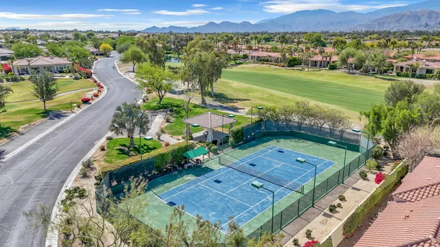 a dining room with wooden floor and chandelier