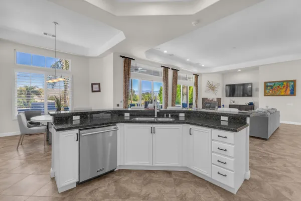 a kitchen with stainless steel appliances granite countertop a sink a stove and cabinets