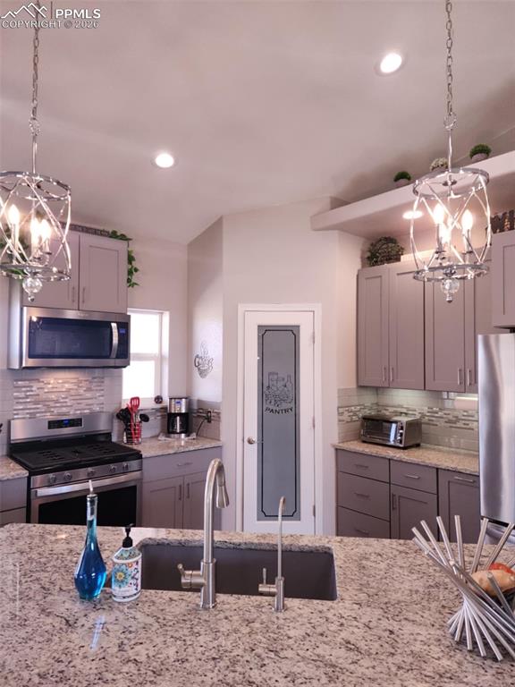 7480 Red Creek Springs Road West Pueblo, CO 81005 - Photo 7 of 47 a kitchen with kitchen island granite countertop a sink cabinets and stainless steel appliances
