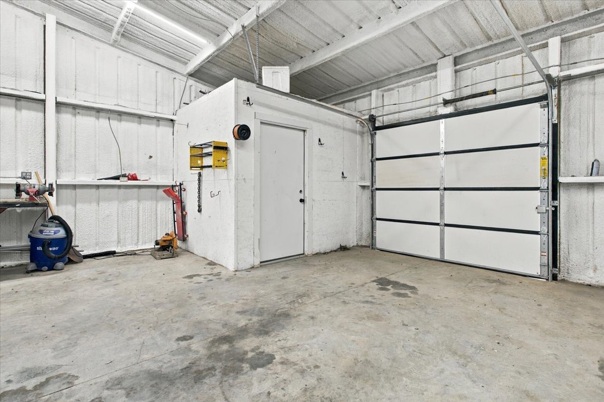 12 Hoot Loop Cartwright, OK 74731 - Photo 23 of 35 Concrete flooring with a white overhead garage door and a white access door