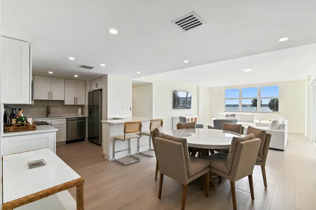 a kitchen with a dining table chairs and white cabinets