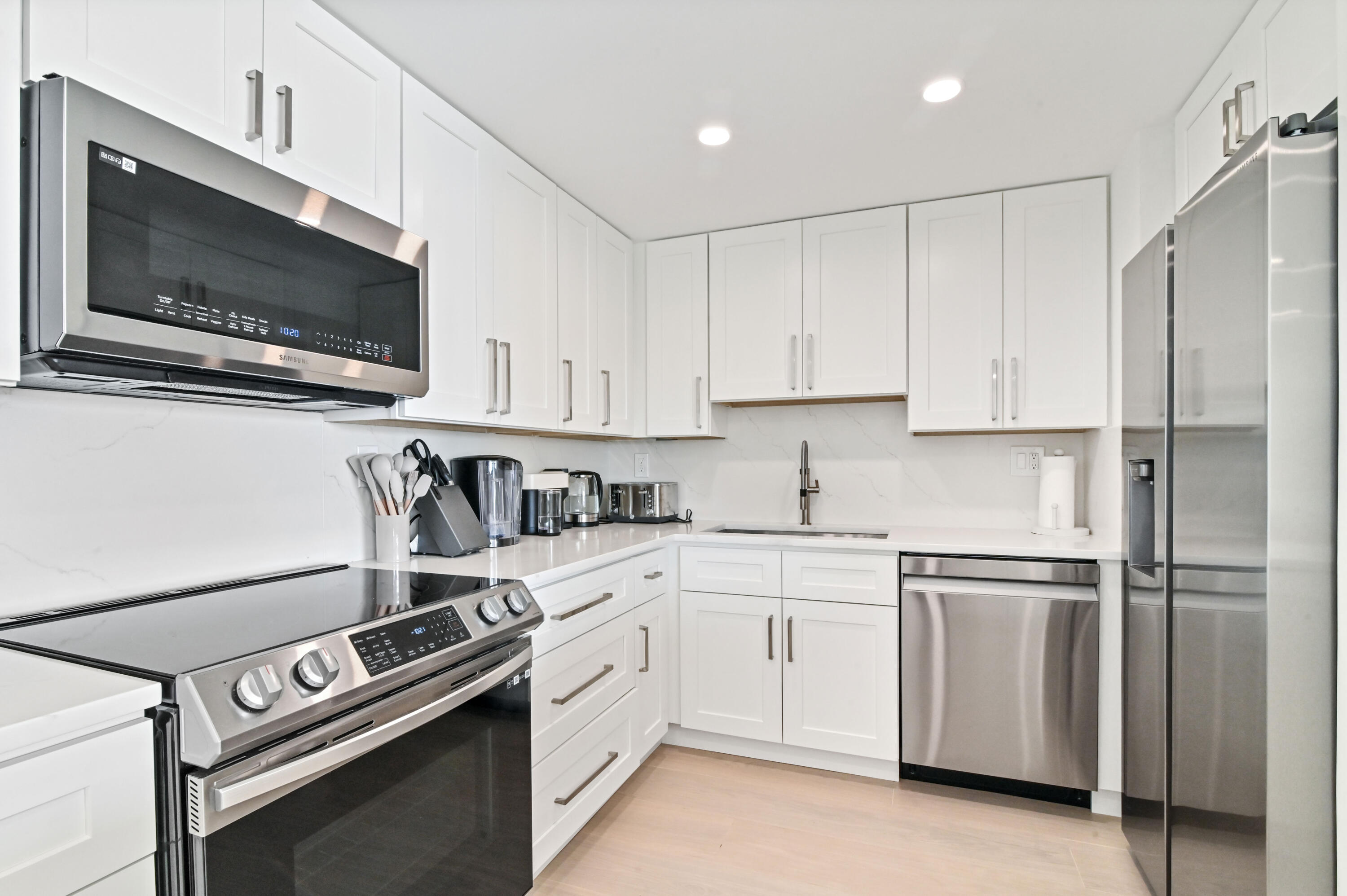 2600 North Flagler Drive, Unit 210 West Palm Beach, FL 33407 - Photo 7 of 25 a kitchen with stainless steel appliances white cabinets and a stove top oven