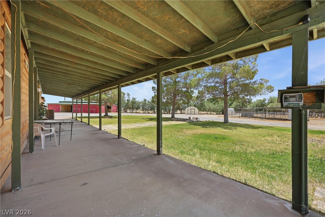 1531 West Harris Farm Road Pahrump, NV 89060 - Photo 15 of 37 A spacious covered porch offers views of a sprawling, verdant yard, ideal for tranquil outdoor living.