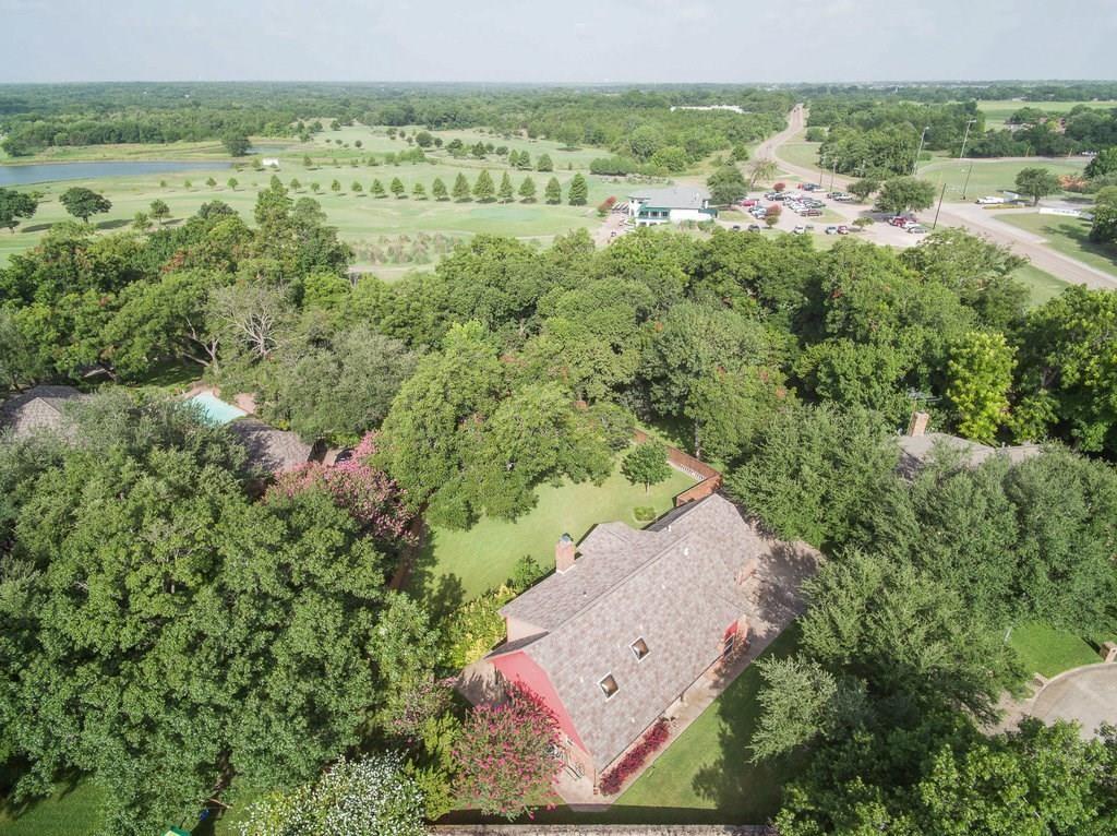 127 Nicklaus Nook Lancaster, TX 75146 - Photo 35 of 37 Aerial property view featuring a red brick structure with a dark shingle roof and multiple skylights