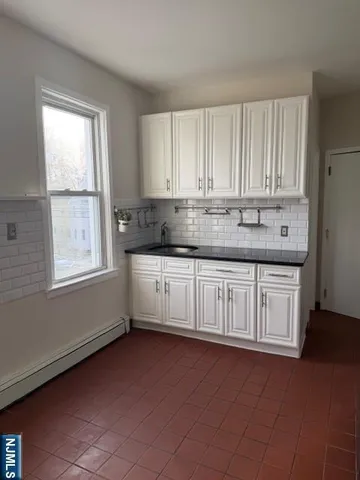 a kitchen with stainless steel appliances granite countertop a sink a stove cabinets and a window