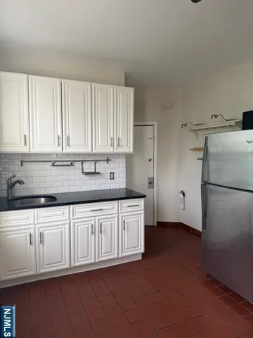 a kitchen with granite countertop a sink and a refrigerator