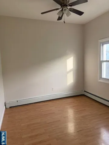 an empty room with a window and a ceiling fan