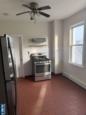 a kitchen with stainless steel appliances a stove a refrigerator and a window