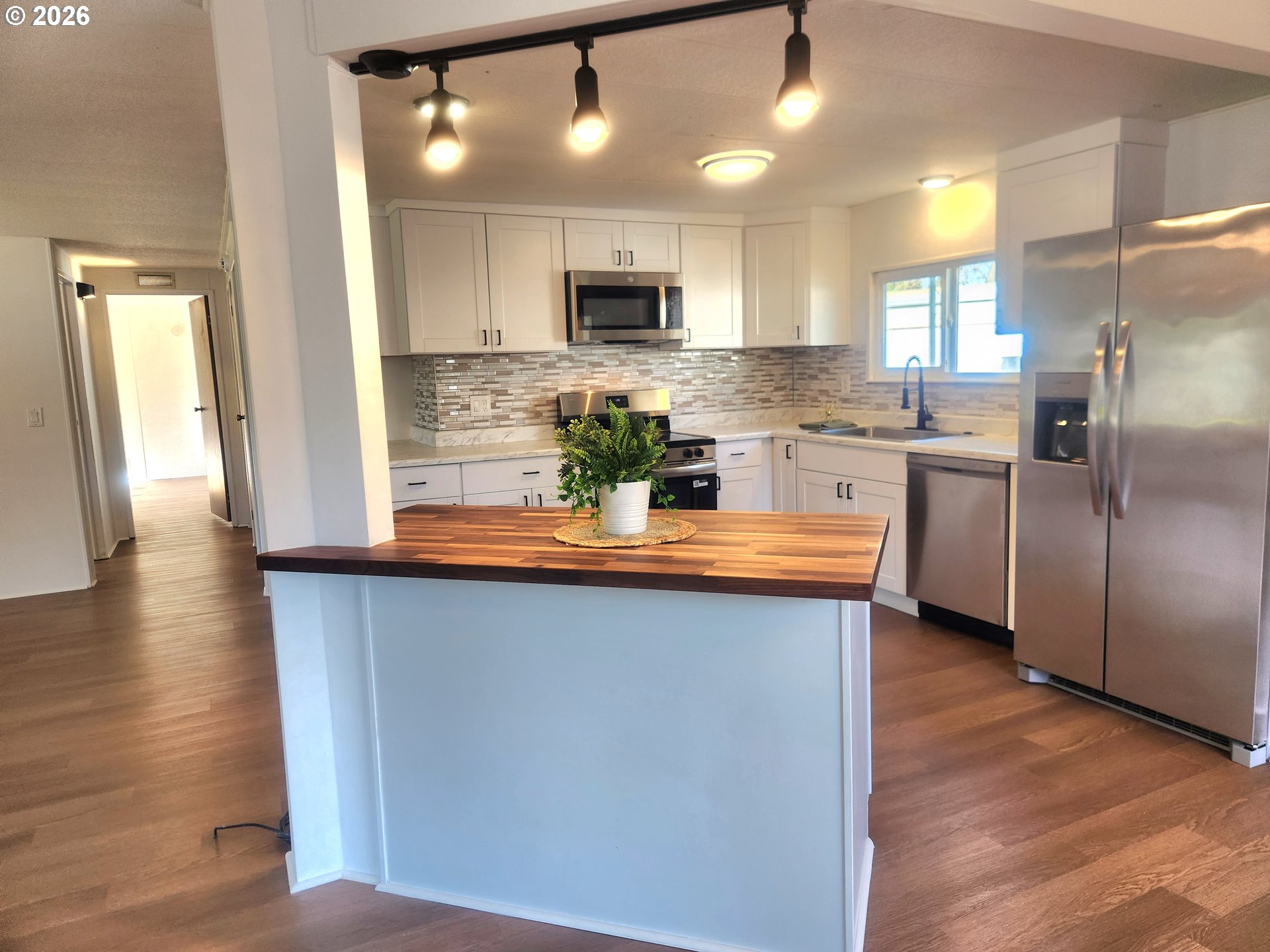 507 North 19th Avenue, Unit 29 Cornelius, OR 97113 - Photo 14 of 26 a kitchen with stainless steel appliances granite countertop a refrigerator a sink dishwasher a oven a dining table and chairs with wooden floor