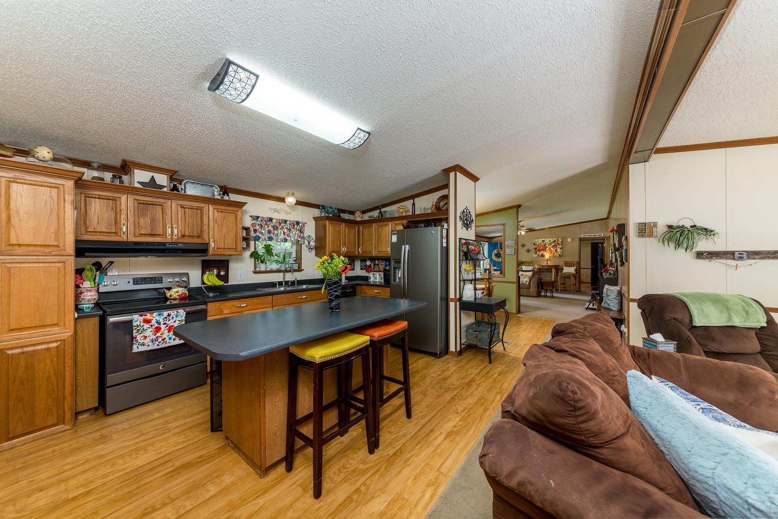 6345 Roy Pearson Road Springfield, TN 37172 - Photo 10 of 30 a living room with furniture a flat screen tv and kitchen view