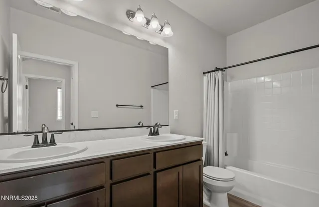a bathroom with a double vanity sink a toilet and a mirror