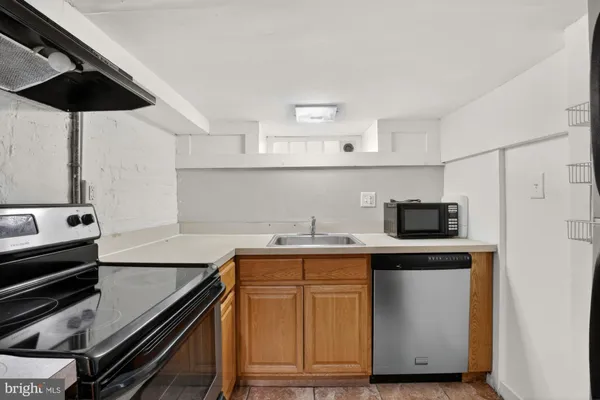 a kitchen with stainless steel appliances a sink a stove and cabinets