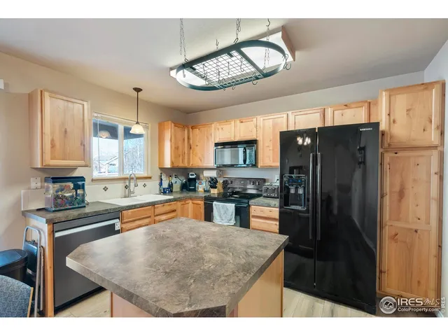 a kitchen with stainless steel appliances granite countertop a refrigerator a sink and a stove