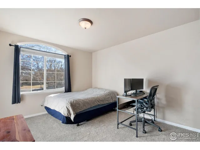 a bedroom with a bed a table and chair