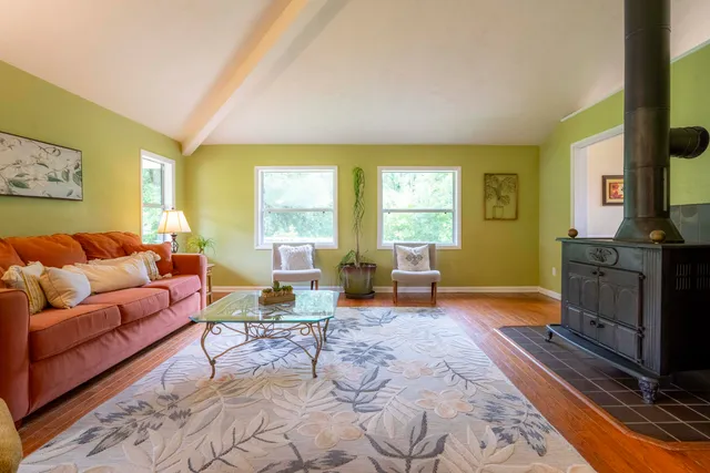 a living room with furniture a fireplace and large windows