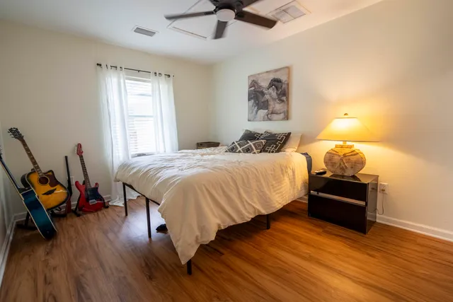 a bedroom with a bed and wooden floor