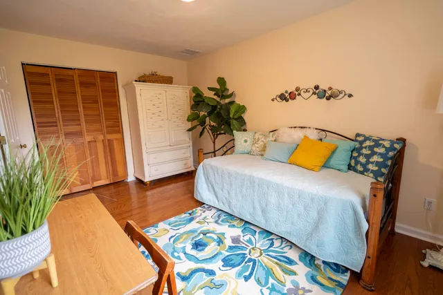 a bedroom with a bed and a potted plant