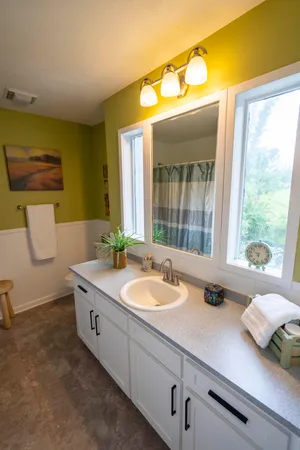 a bathroom with a granite countertop sink and a large mirror