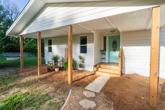 a view of a house with backyard porch and sitting area