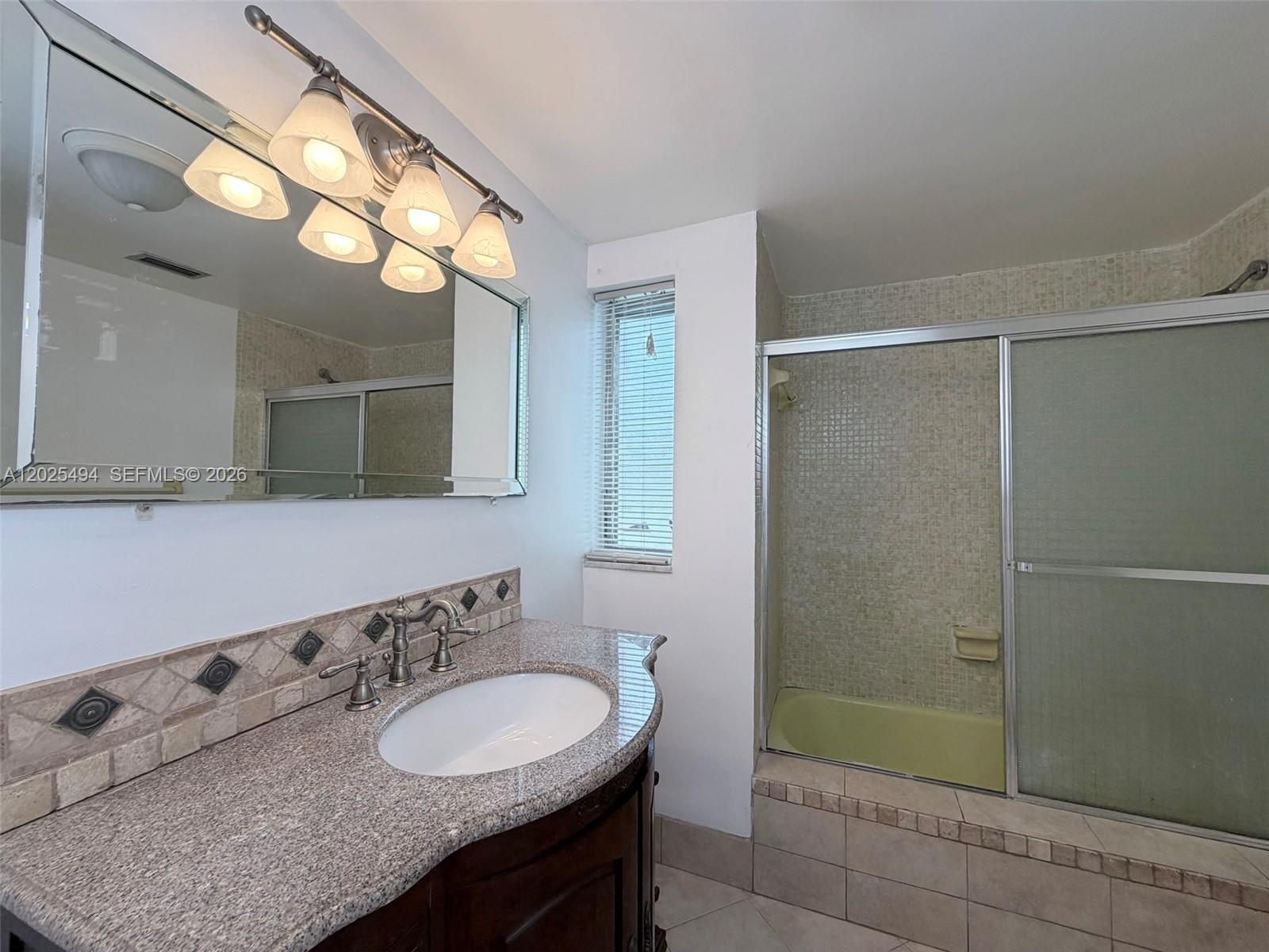 9159 Southwest 77th Avenue, Unit 112 Miami, FL 33156 - Photo 29 of 38 a bathroom with a sink and a mirror