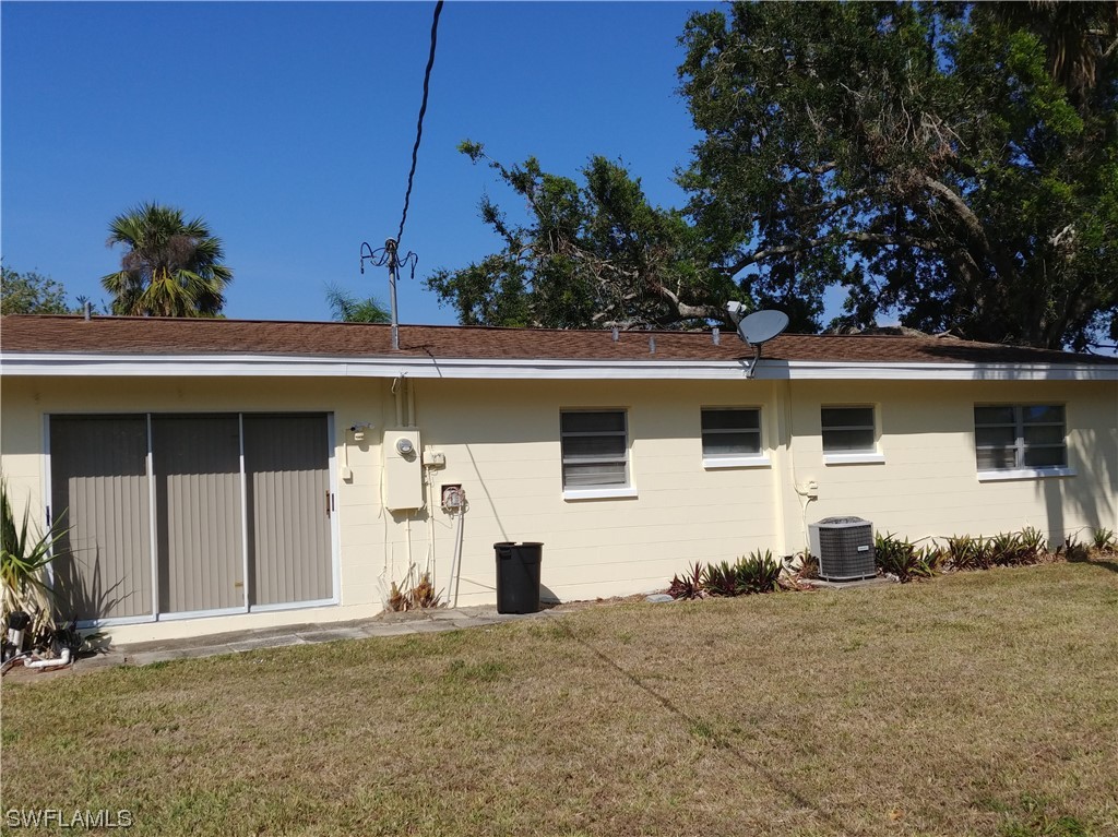 112 Clayton Avenue Lehigh Acres, FL 33936 - Photo 14 of 16 a front view of a house with a yard