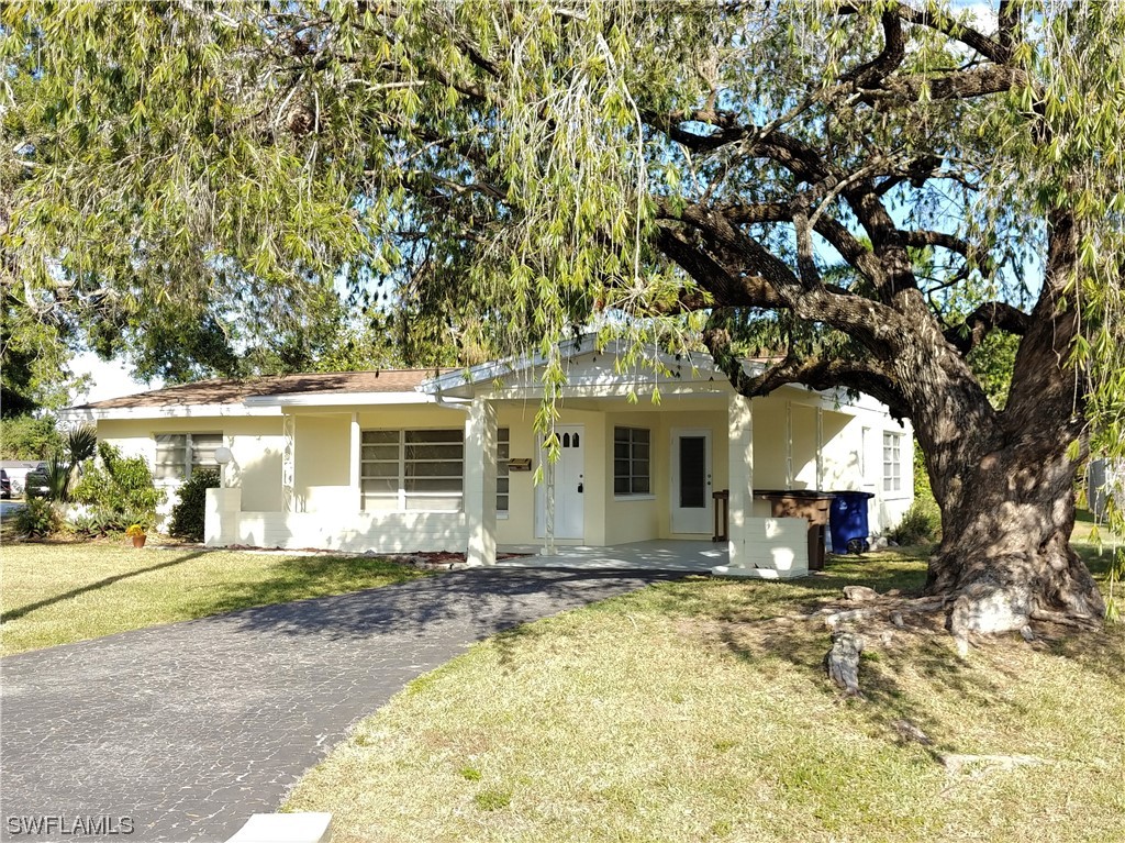 112 Clayton Avenue Lehigh Acres, FL 33936 - Photo 2 of 16 front view of a house with a yard