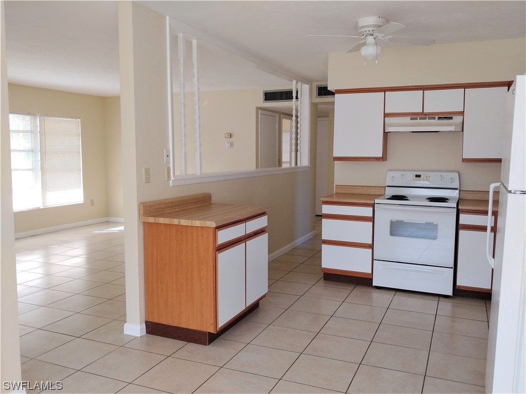 112 Clayton Avenue Lehigh Acres, FL 33936 - Photo 7 of 16 a kitchen with cabinets and appliances