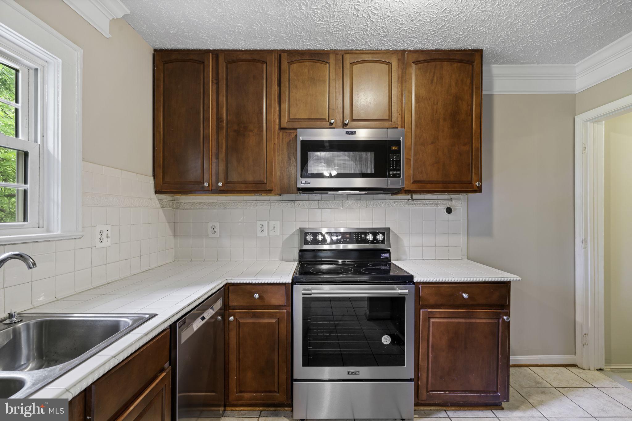19316 Weaver Road Triangle, VA 22172 - Photo 13 of 33 a kitchen with a sink stove and microwave