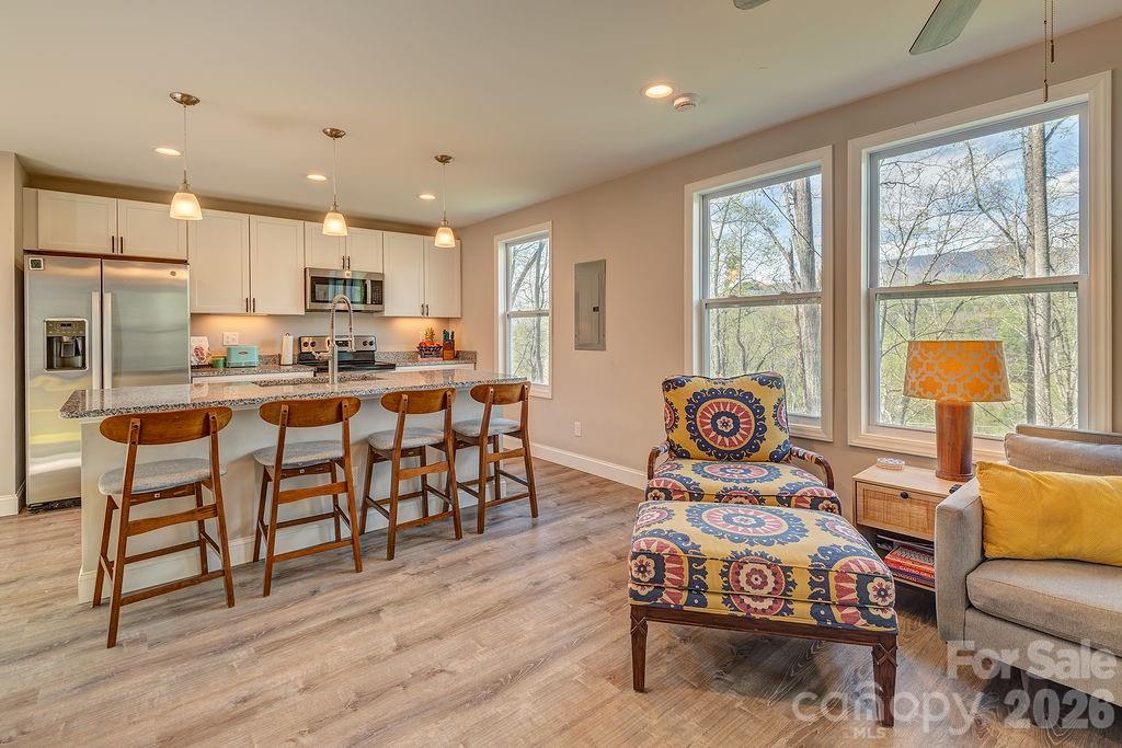 343 Garren Creek Road Fairview, NC 28730 - Photo 11 of 30 a living room with kitchen island furniture and a large window