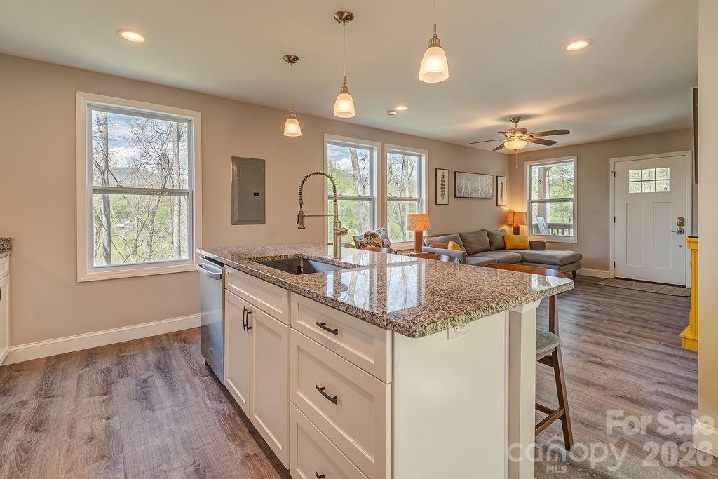 343 Garren Creek Road Fairview, NC 28730 - Photo 13 of 30 a kitchen with stainless steel appliances granite countertop a sink stove and wooden floor