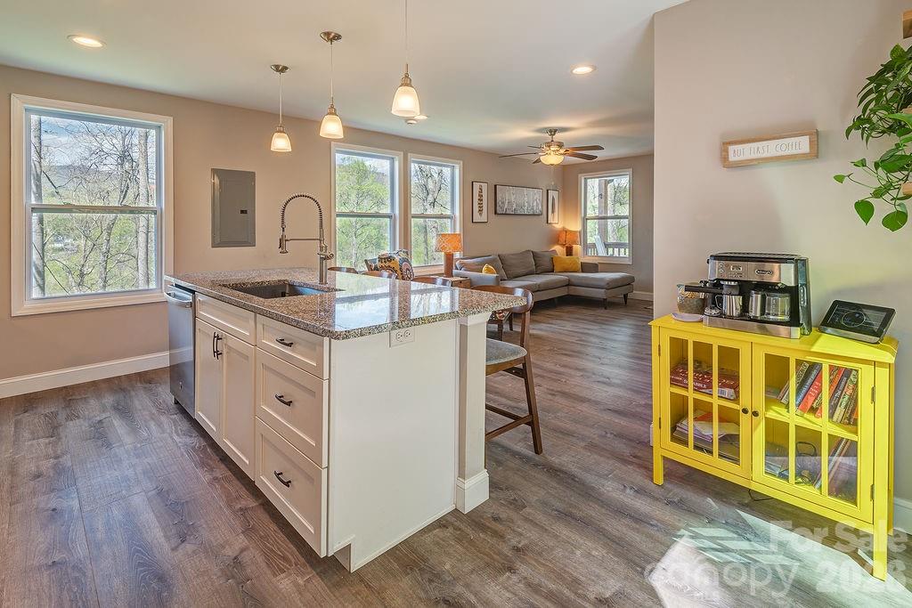 343 Garren Creek Road Fairview, NC 28730 - Photo 17 of 30 a open kitchen with stainless steel appliances granite countertop a stove and a large window with wooden floors