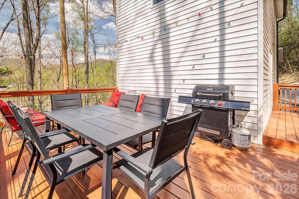343 Garren Creek Road Fairview, NC 28730 - Photo 19 of 30 a roof deck with a dining table and chairs with wooden floor