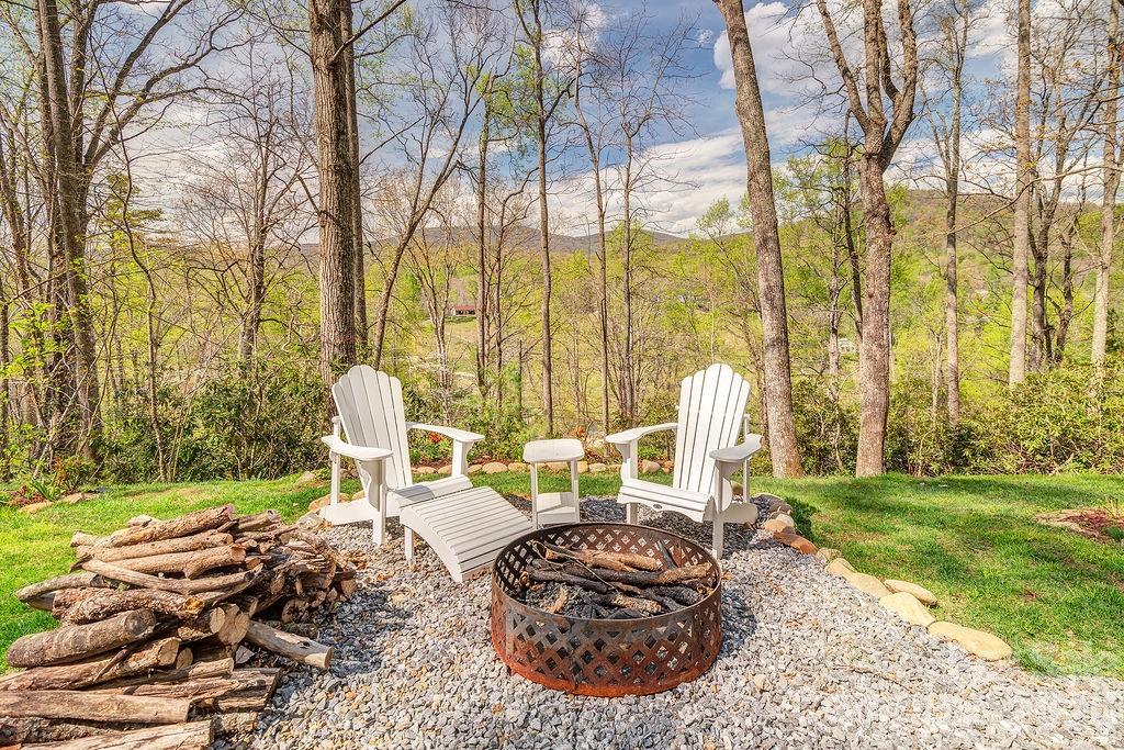 343 Garren Creek Road Fairview, NC 28730 - Photo 2 of 30 a view of a backyard with lawn chairs potted plants and large tree