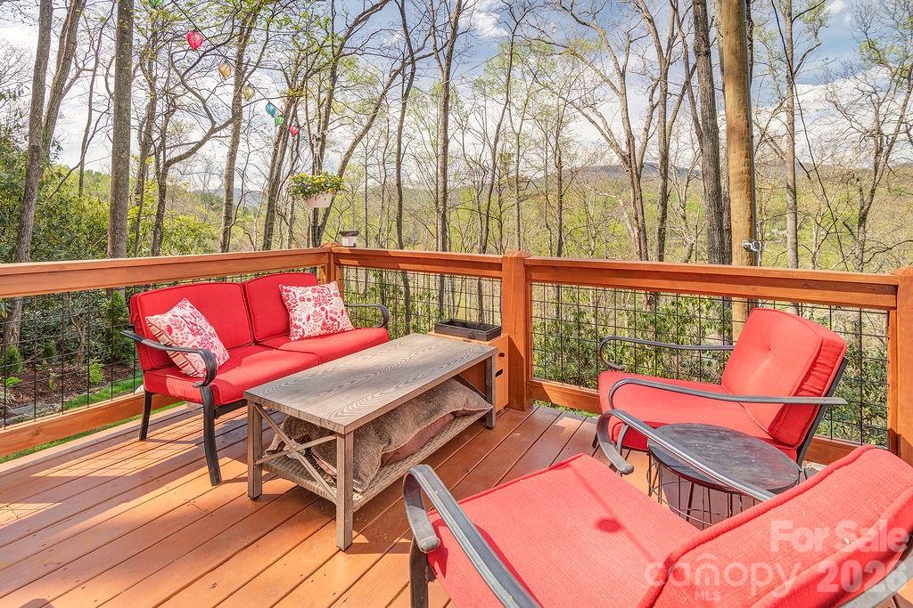 343 Garren Creek Road Fairview, NC 28730 - Photo 21 of 30 a roof deck with a table and chairs with wooden floor and fence