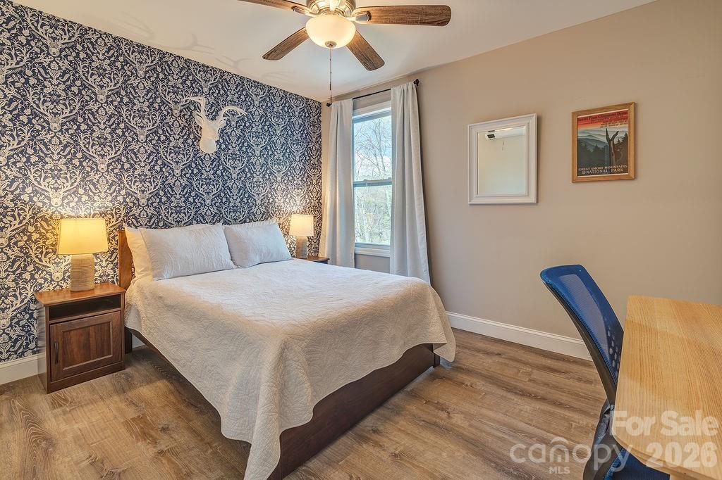 343 Garren Creek Road Fairview, NC 28730 - Photo 25 of 30 a bedroom with a bed and a chandelier