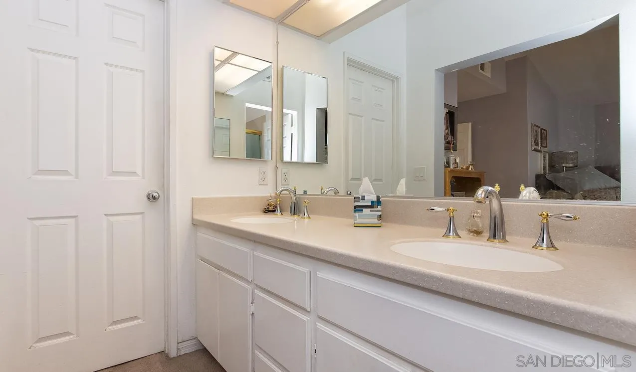 14140 Carmel Ridge Road San Diego, CA 92128 - Photo 11 of 17 a bathroom with double vanity sinks and a mirror