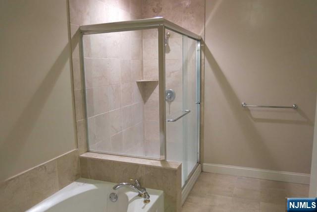 116 The Promenade, Unit 116 Edgewater, NJ 07020 - Photo 13 of 26 a bathroom with a bathtub and a shower