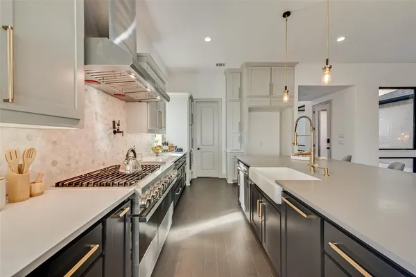 a kitchen with kitchen island stainless steel appliances a sink stove and cabinets