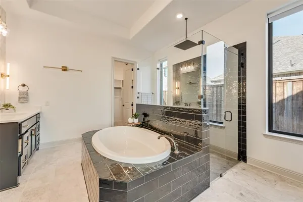 a bathroom with a granite countertop sink a mirror a vanity and shower