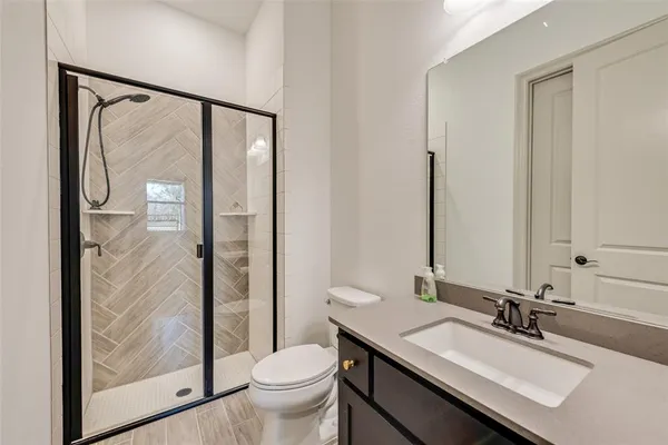 a bathroom with a granite countertop sink toilet and shower