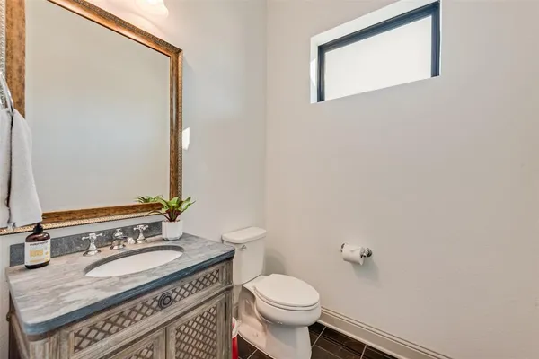 a bathroom with a granite countertop sink a mirror and a toilet