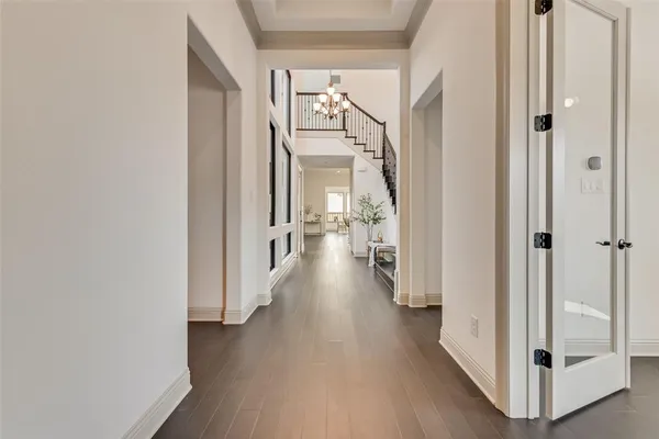 a view of a hallway with wooden floor and closet