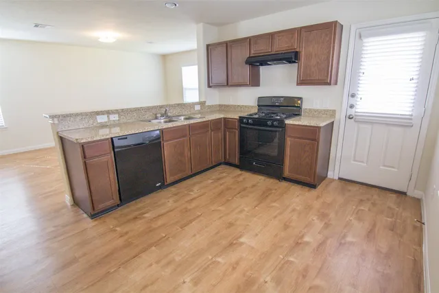 a kitchen with stainless steel appliances granite countertop a stove a sink and a refrigerator