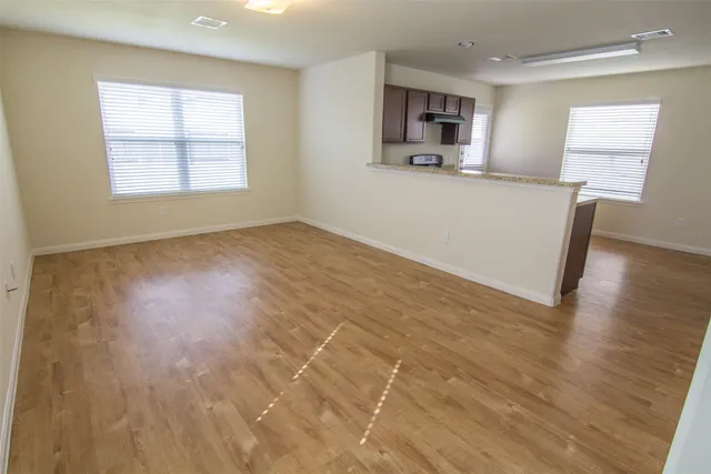 a view of a kitchen with wooden floor and a window