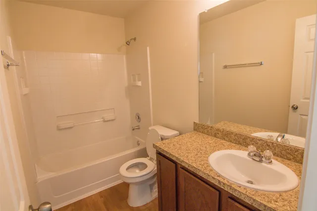 a bathroom with a granite countertop sink toilet and shower