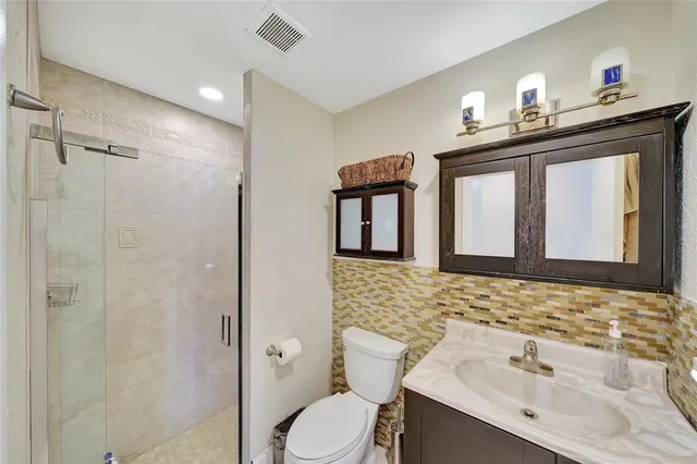 a bathroom with a sink vanity mirror and toilet