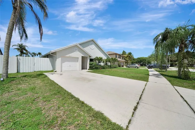 a view of house with yard and tree in front of it