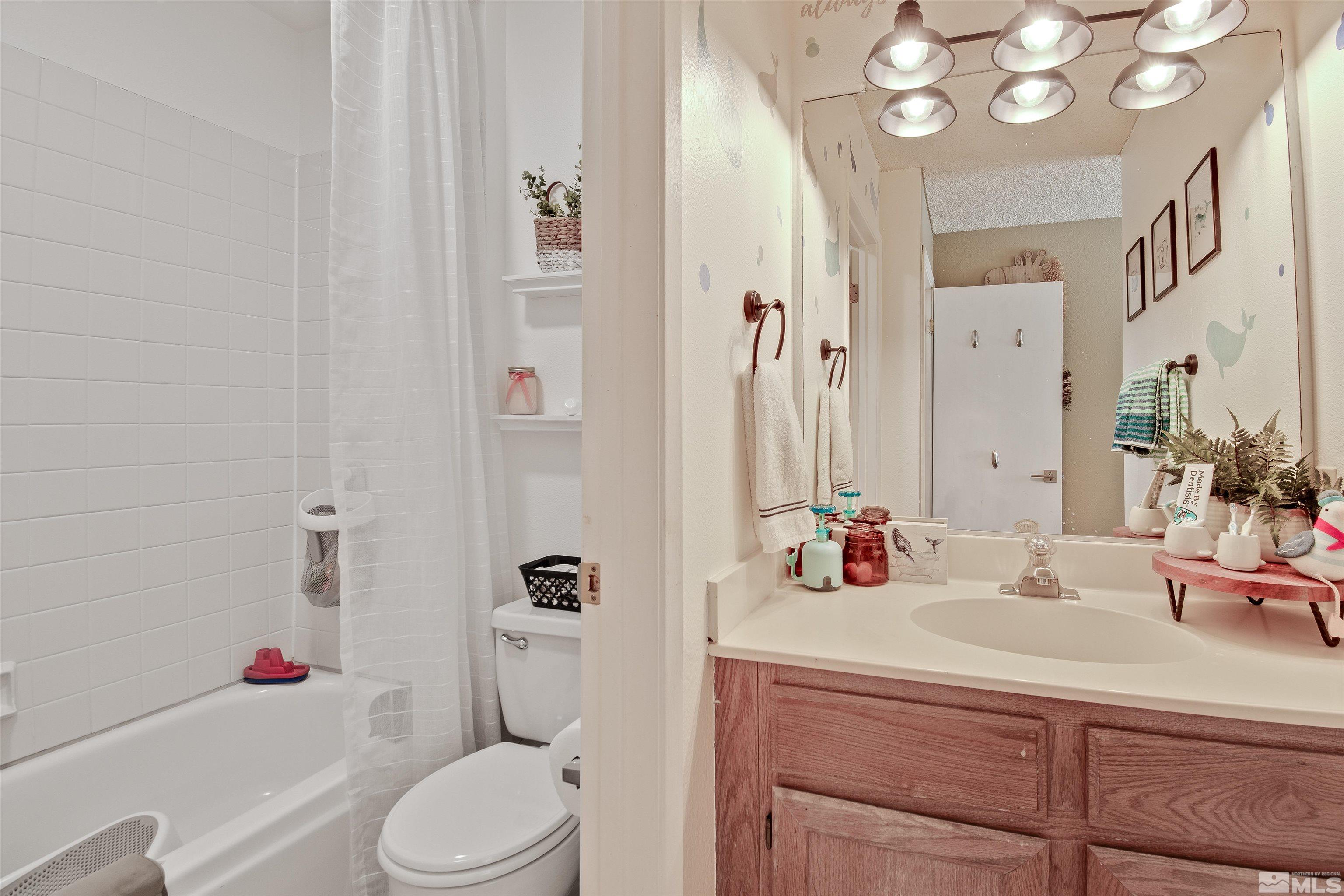 3961 Kings Row Reno, NV 89503 - Photo 19 of 25 a bathroom with a sink vanity mirror and toilet