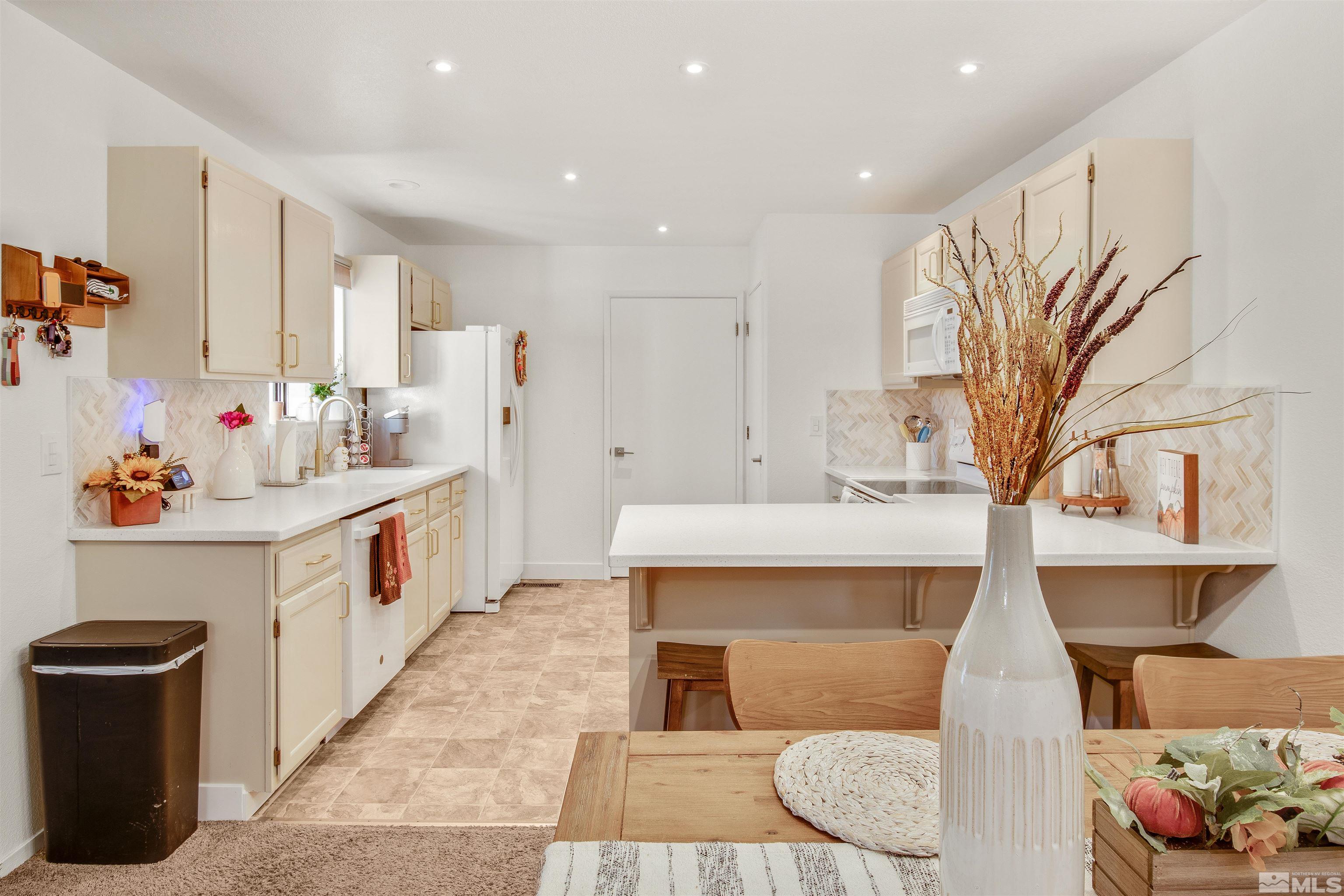 3961 Kings Row Reno, NV 89503 - Photo 7 of 25 a kitchen with stainless steel appliances kitchen island granite countertop a sink and a refrigerator